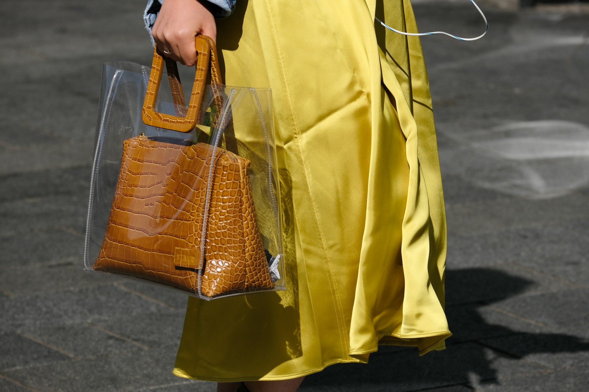 Dettaglio di una borsa in pelle marrone tenuta in mano